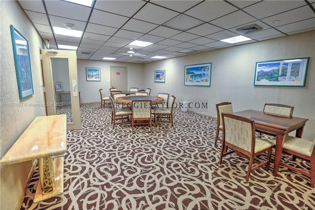 dining room featuring carpet and a paneled ceiling