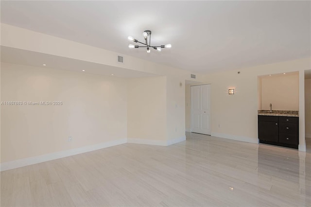 unfurnished room featuring a chandelier