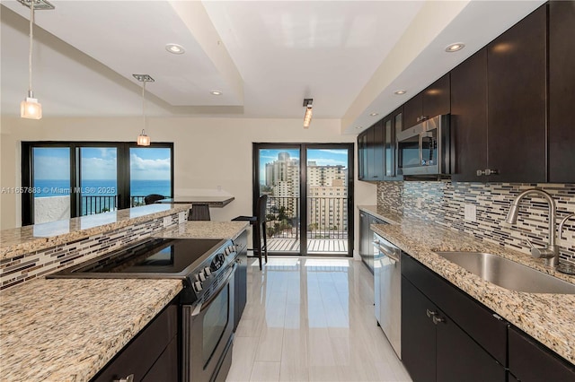 kitchen with sink, a water view, plenty of natural light, pendant lighting, and stainless steel appliances