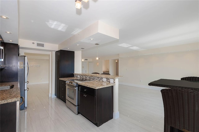 kitchen featuring stainless steel appliances, light stone countertops, kitchen peninsula, and hanging light fixtures