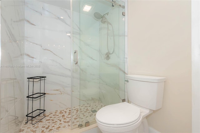 bathroom with toilet and a shower with shower door