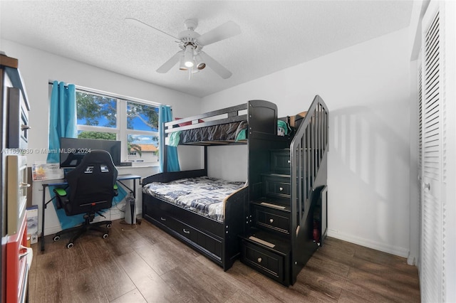 bedroom with dark wood-type flooring, ceiling fan, and a textured ceiling