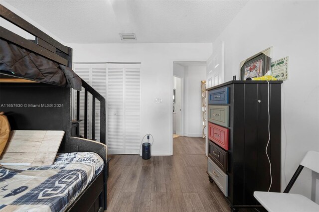 bedroom featuring a textured ceiling, hardwood / wood-style flooring, and a closet