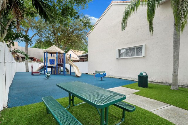 exterior space with a playground and a lawn