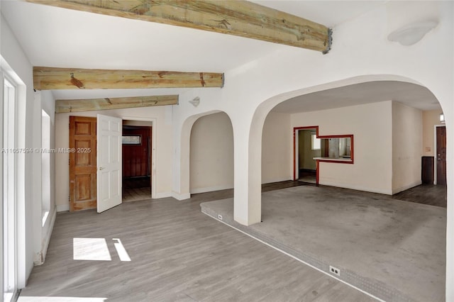 unfurnished room with hardwood / wood-style flooring and beam ceiling