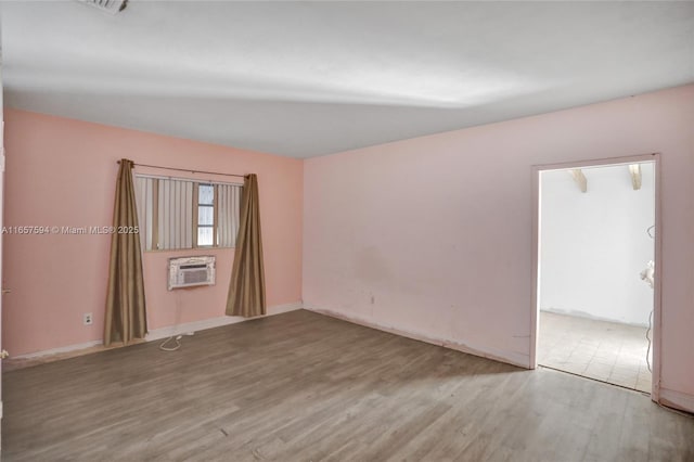 spare room featuring hardwood / wood-style flooring and a wall mounted AC