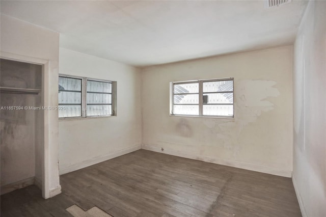 unfurnished bedroom featuring a closet and dark hardwood / wood-style flooring