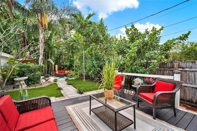 wooden terrace with fence, a lawn, and an outdoor hangout area