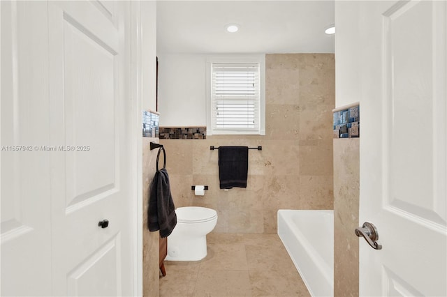 bathroom featuring toilet, a tub, tile walls, and tile patterned floors