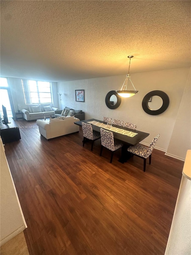 unfurnished dining area featuring a textured ceiling and dark hardwood / wood-style flooring