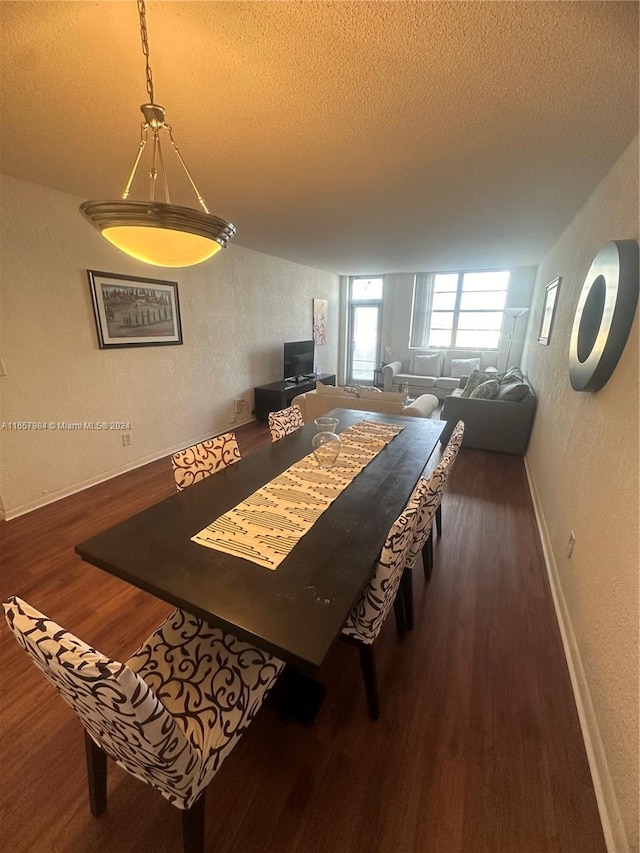 dining area with a textured ceiling and dark hardwood / wood-style flooring