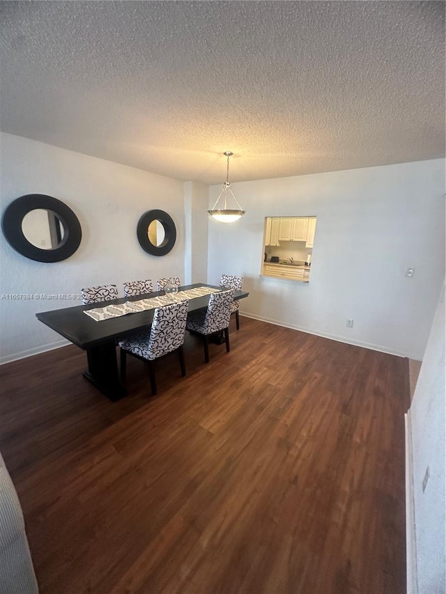 dining space with a textured ceiling and dark hardwood / wood-style floors