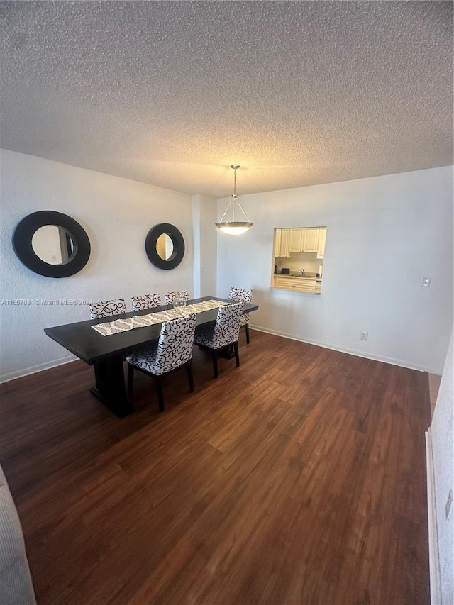 dining room with a textured ceiling and dark hardwood / wood-style floors