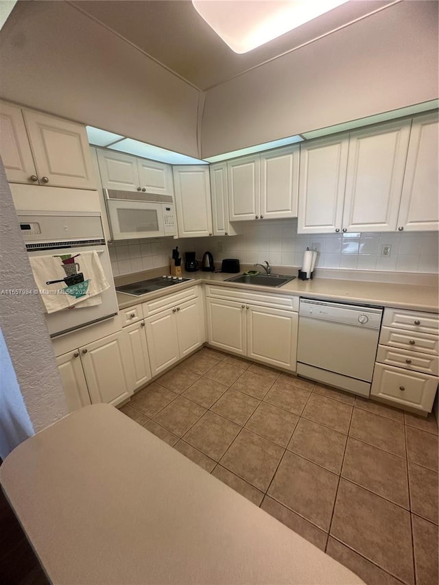 kitchen with backsplash, sink, light tile patterned floors, white cabinetry, and white appliances