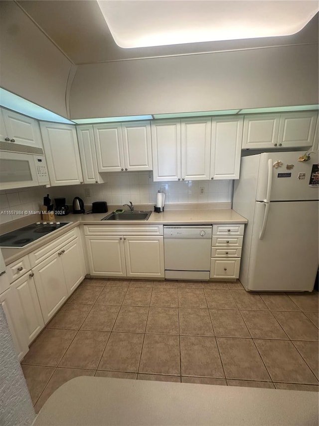 kitchen featuring decorative backsplash, sink, light tile patterned floors, white cabinets, and white appliances