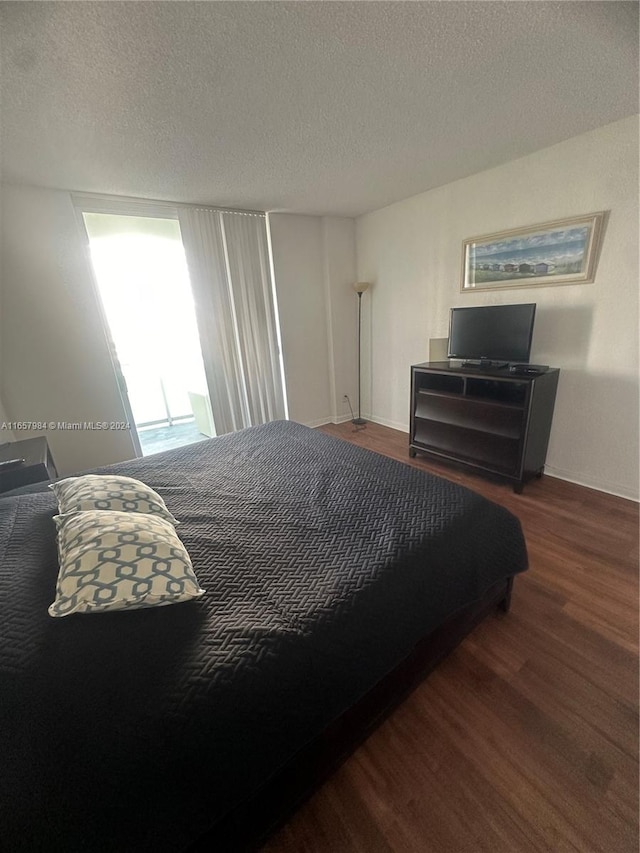 bedroom with dark wood-type flooring and a textured ceiling