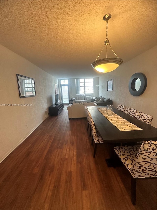 dining room featuring a textured ceiling and dark hardwood / wood-style flooring