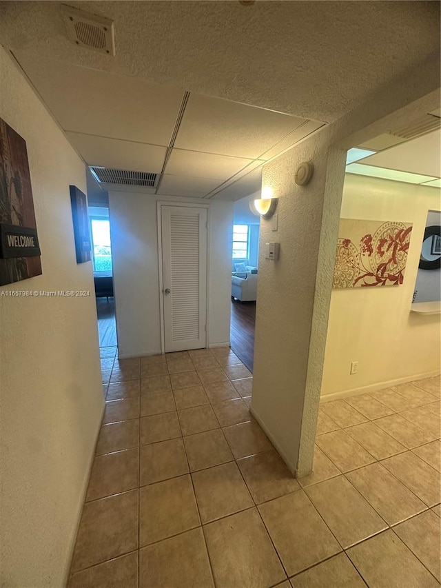 hall featuring a wealth of natural light and tile patterned flooring