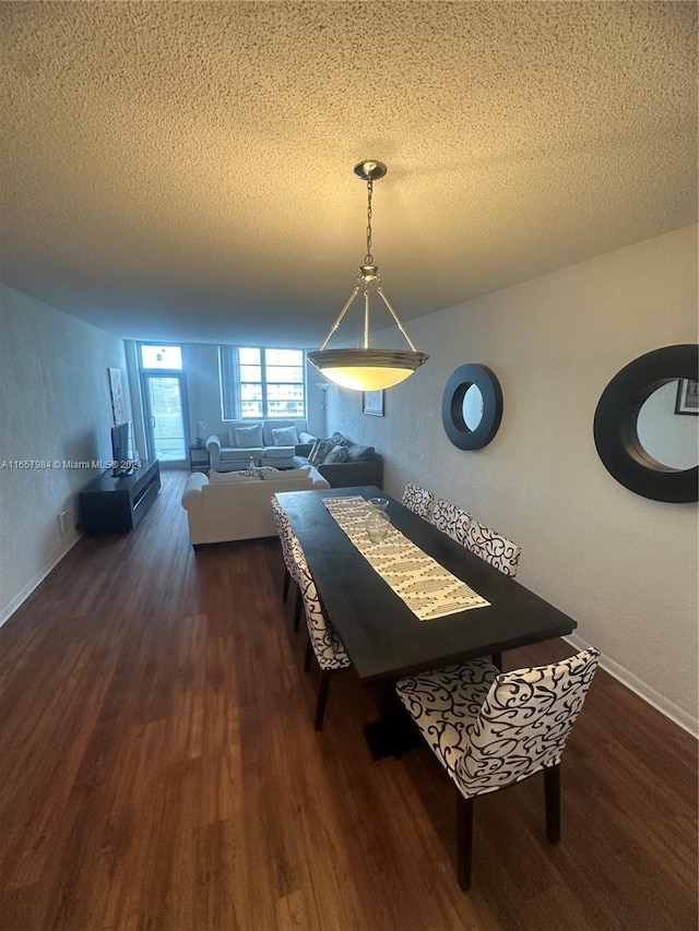 dining area with a textured ceiling and dark wood-type flooring