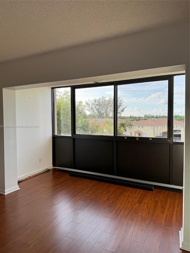 spare room with a textured ceiling and wood-type flooring