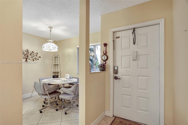 tiled entryway featuring a textured ceiling