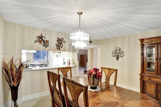 dining space featuring a chandelier and a textured ceiling