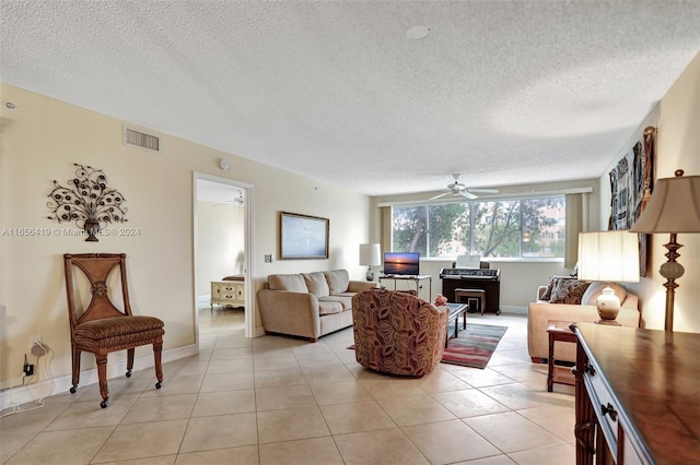 tiled living room with ceiling fan and a textured ceiling