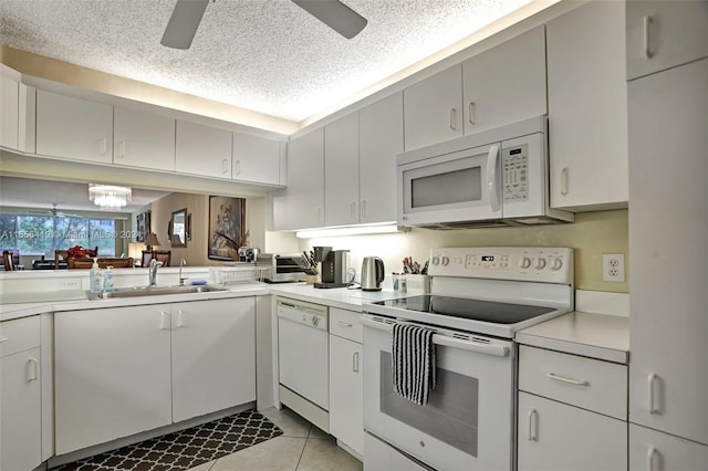 kitchen with white cabinets, white appliances, sink, and a textured ceiling