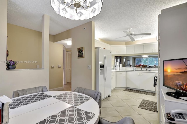 kitchen with white fridge with ice dispenser, white cabinetry, a textured ceiling, and ceiling fan