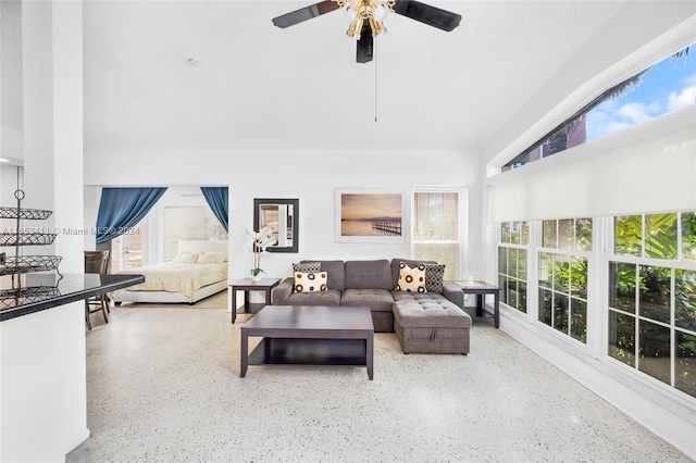 living area featuring speckled floor, a healthy amount of sunlight, and ceiling fan