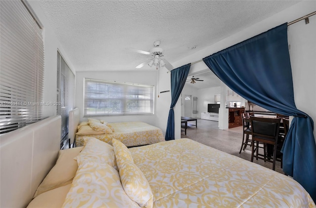 bedroom featuring lofted ceiling, a textured ceiling, and a ceiling fan