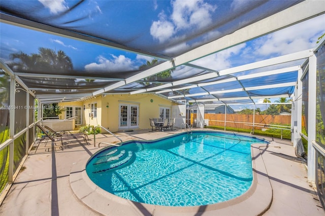 view of pool featuring glass enclosure, french doors, a fenced in pool, fence, and a patio area