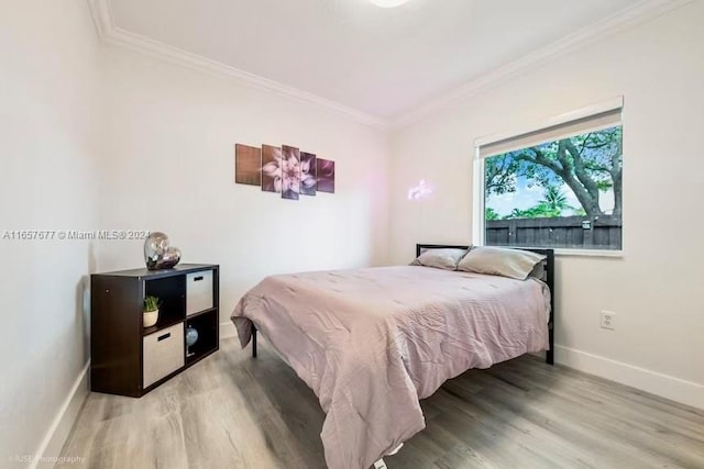 bedroom with ornamental molding and hardwood / wood-style flooring