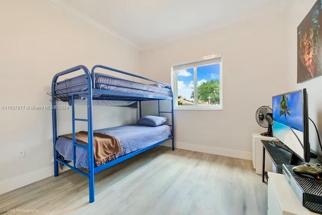 bedroom featuring light wood-type flooring and crown molding