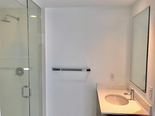 bathroom with vanity and a shower with shower door