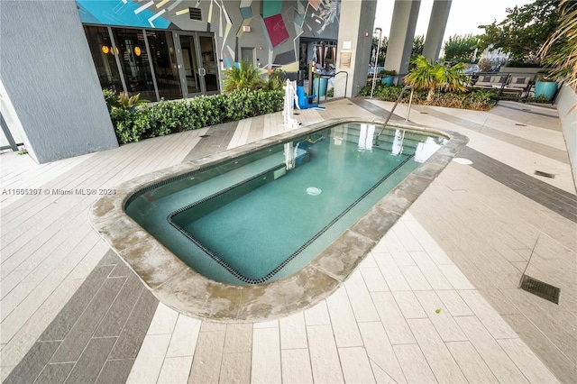 view of swimming pool featuring a hot tub