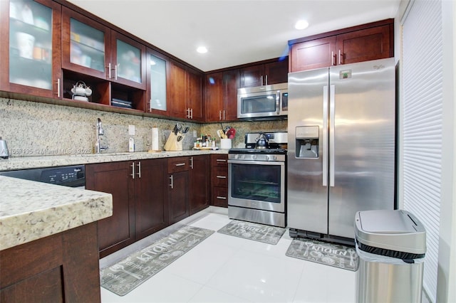 kitchen with sink, backsplash, stainless steel appliances, and light tile patterned flooring