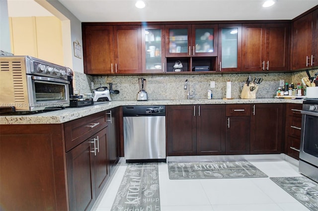 kitchen with dishwasher, backsplash, light stone counters, and sink