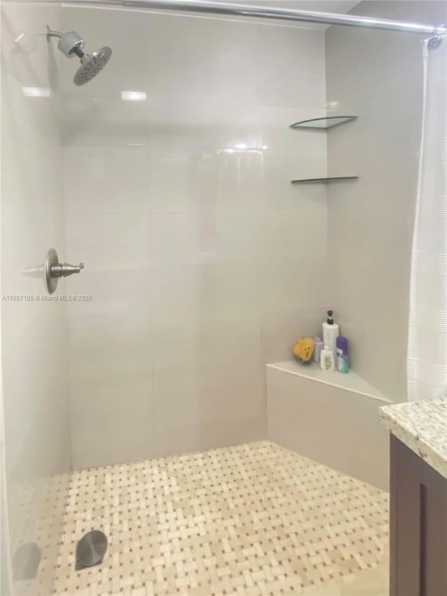 bathroom featuring walk in shower, vanity, and tile patterned flooring