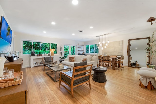 living room featuring an inviting chandelier and light wood-type flooring