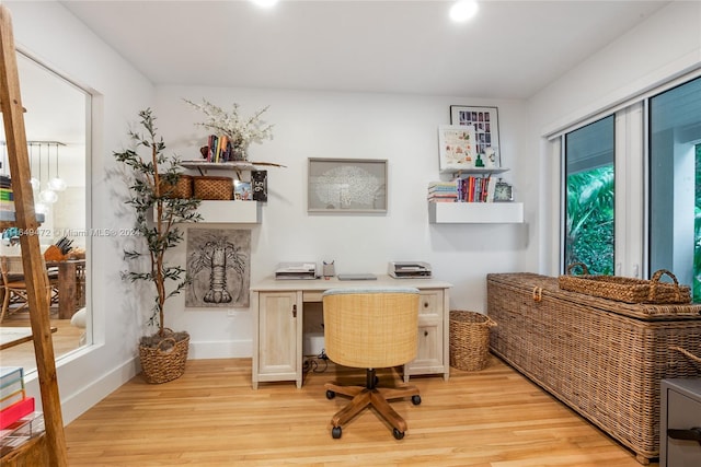 office space with built in desk and light hardwood / wood-style flooring