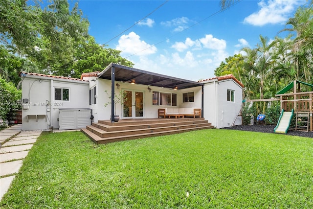 back of house featuring a yard, french doors, a deck, and a playground