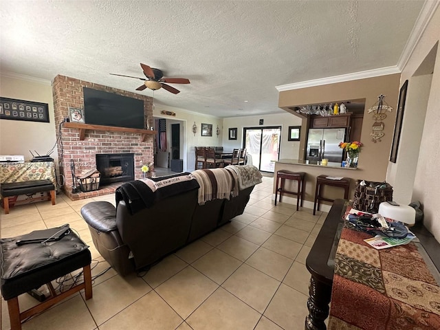 tiled living room with ceiling fan, ornamental molding, a brick fireplace, and a textured ceiling