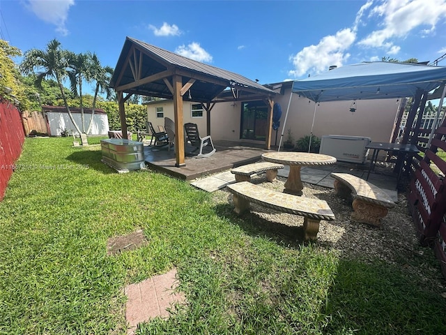 back of property featuring a lawn, a patio area, a storage shed, and a gazebo