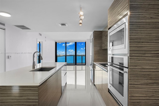 kitchen featuring visible vents, modern cabinets, stainless steel appliances, and expansive windows