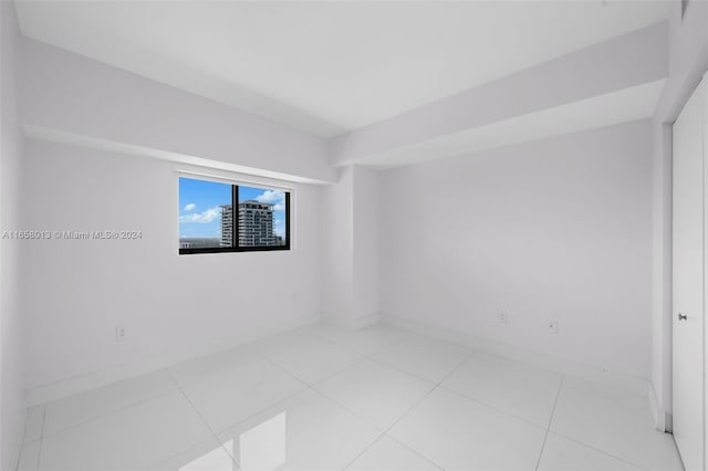 empty room featuring tile patterned floors and baseboards