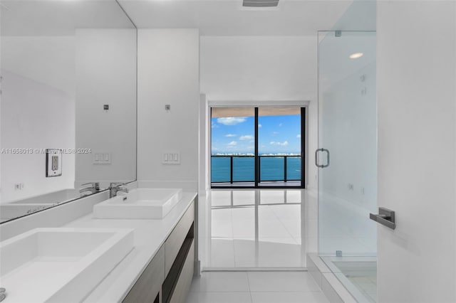 full bath with tile patterned flooring, a shower stall, double vanity, and a sink