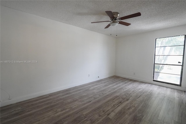 empty room featuring dark hardwood / wood-style flooring, a textured ceiling, and ceiling fan