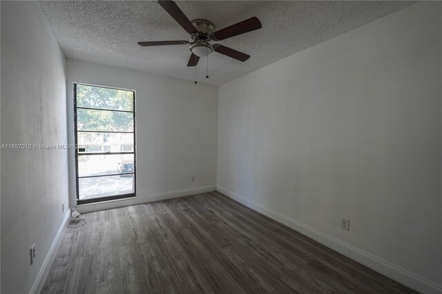 unfurnished room with ceiling fan, dark wood-type flooring, and a textured ceiling