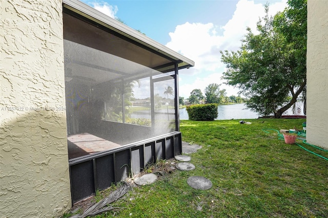 view of yard featuring a water view and a sunroom